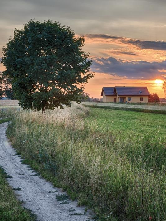 Farm house and county driveway at sunset